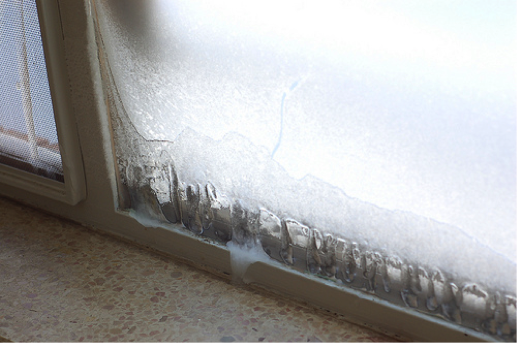 Image of a window with servere condensation and ice buidup